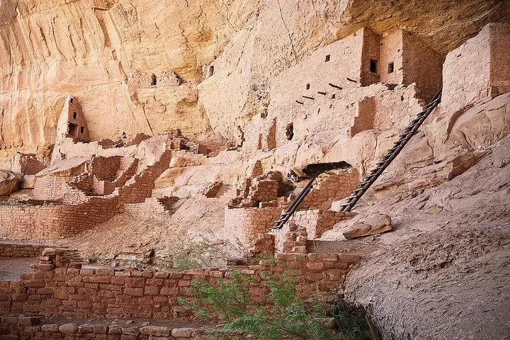 Ancient stone structures built into a large cliff face.
