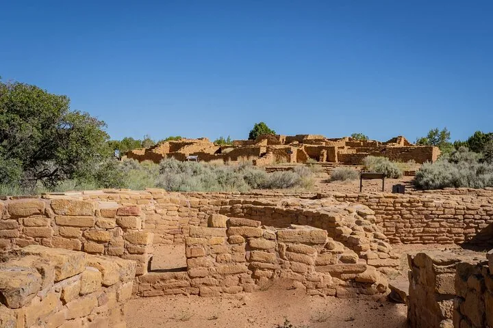 Ruins of ancient stone buildings against a clear blue sky.